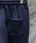 Dark navy track pants with front patch pocket and elastic waistband