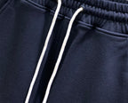 Navy drawstring track pants with two white cords and ribbed waistband