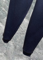 Navy track pants with tapered legs and elastic ankle cuffs