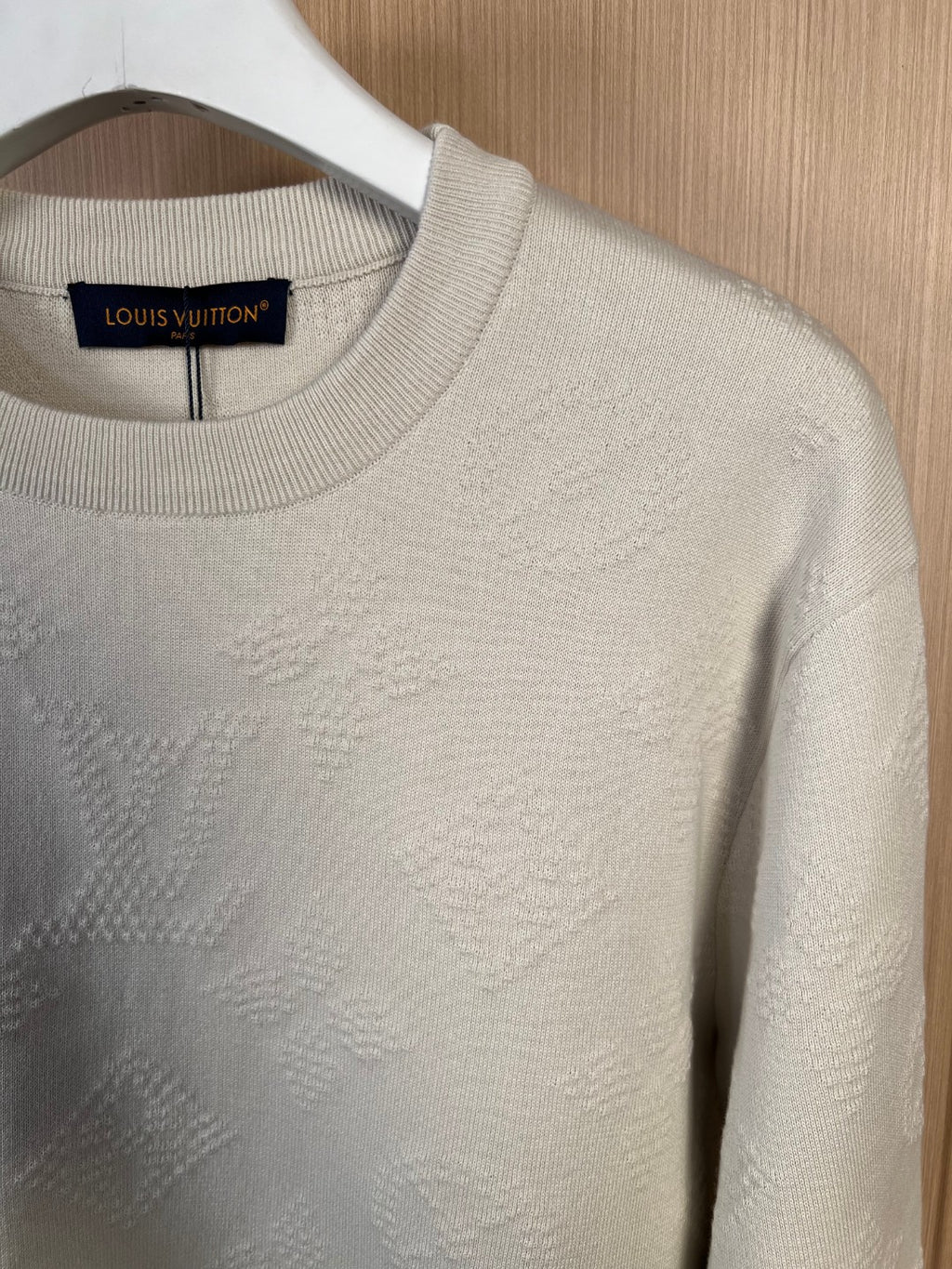 Cream crew-neck sweater close-up, textured knit front panel