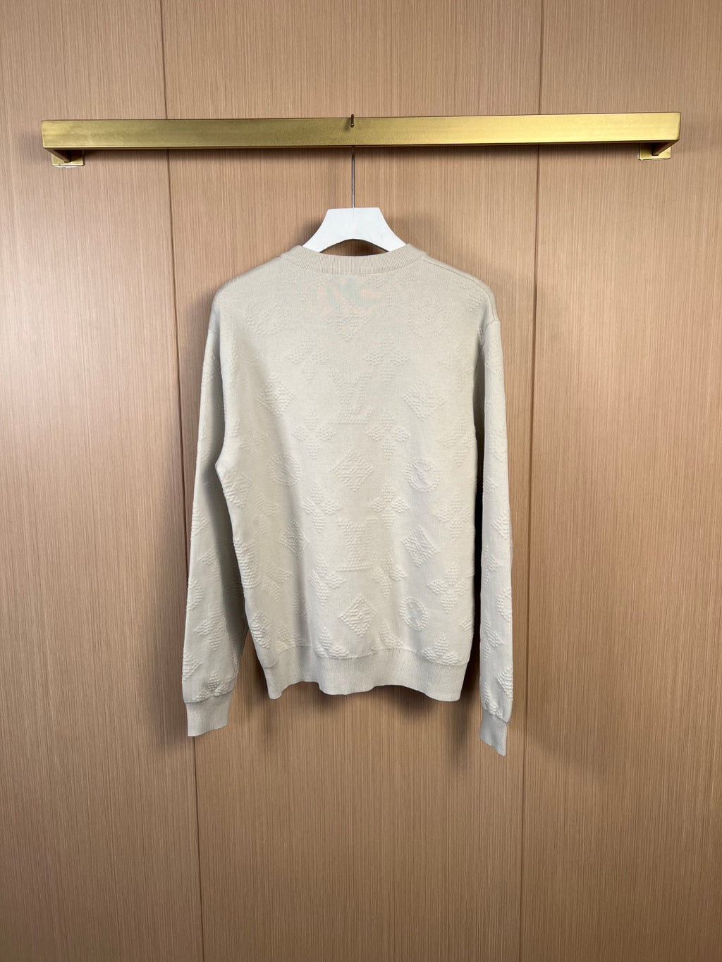 Cream long-sleeve sweater, back view on hanger