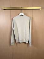 Cream long-sleeve sweater, back view on hanger