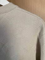 Cream long-sleeve sweater close-up, textured knit on back