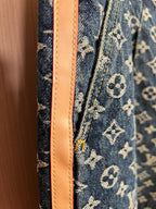 Louis Vuitton denim side seam with tan leather-like trim on monogram fabric