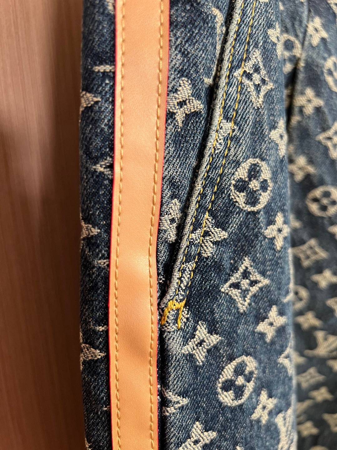 Louis Vuitton denim side seam with tan leather-like trim on monogram fabric
