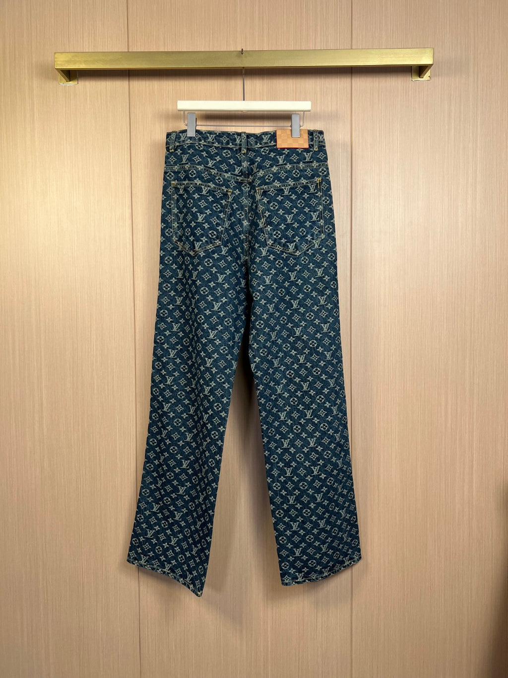 Louis Vuitton monogram denim pants on hanger, dark blue with logo repeat print