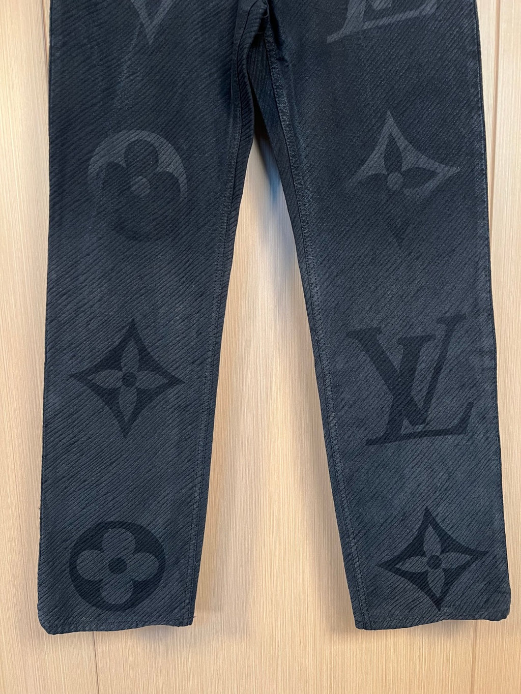 Dark denim pants with all-over monogram motifs on both legs