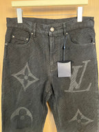 Louis Vuitton monogram jeans with front pockets and snap button hardware, close-up.