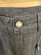 Dark denim pants waistband with round logo button and stitched details