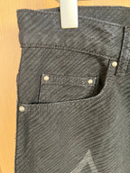 Dark denim pants with front patch pockets and metal stud buttons