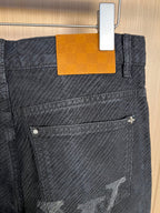 Dark denim pants with orange patch on waistband and front pocket stitching