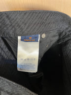 Jeans interior care tag attached near waistband, close-up.