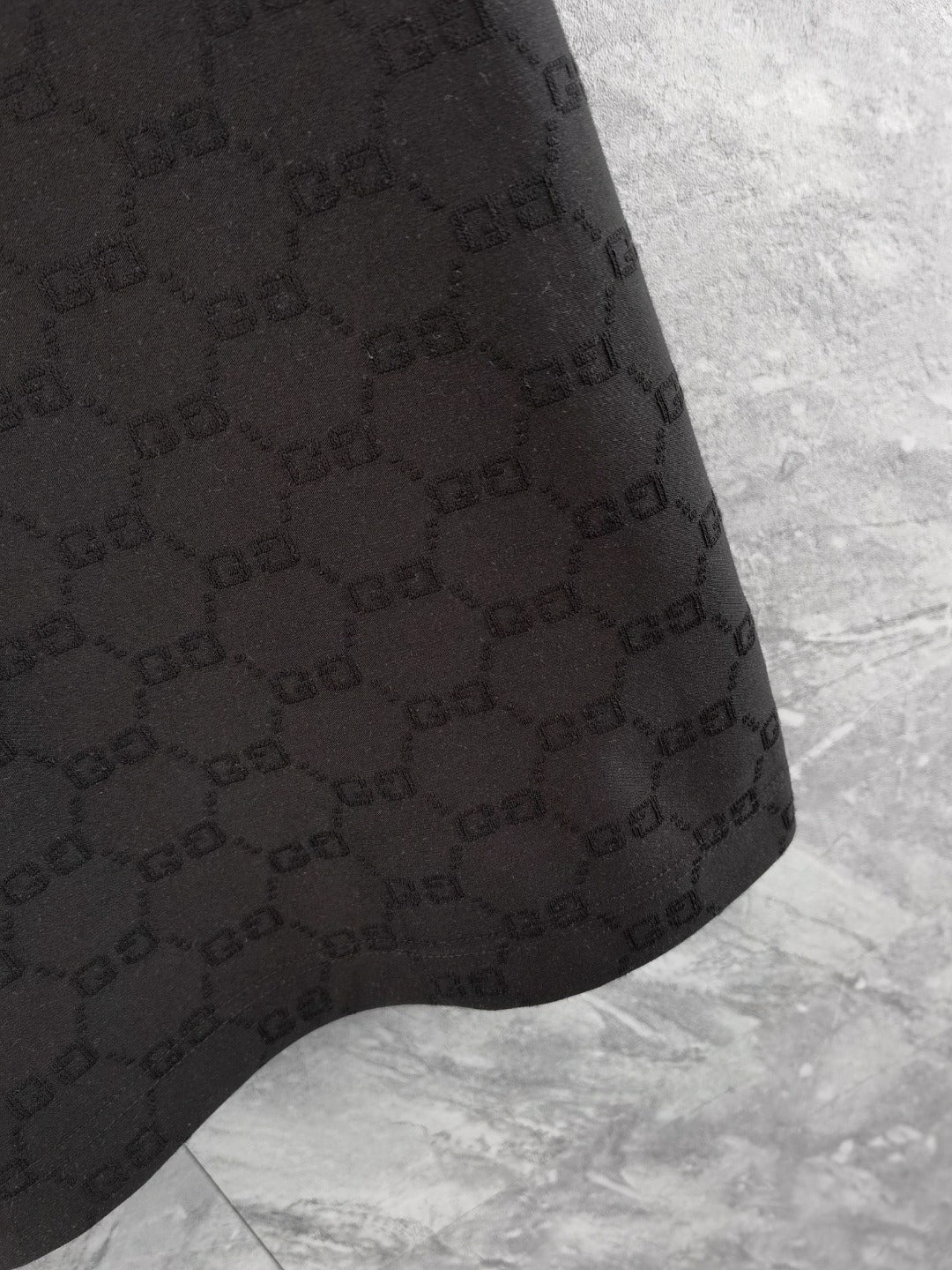 Gucci polo shirt hem, black with textured interlocking pattern