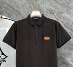 Black monogram polo shirt close-up with button placket and chest patch