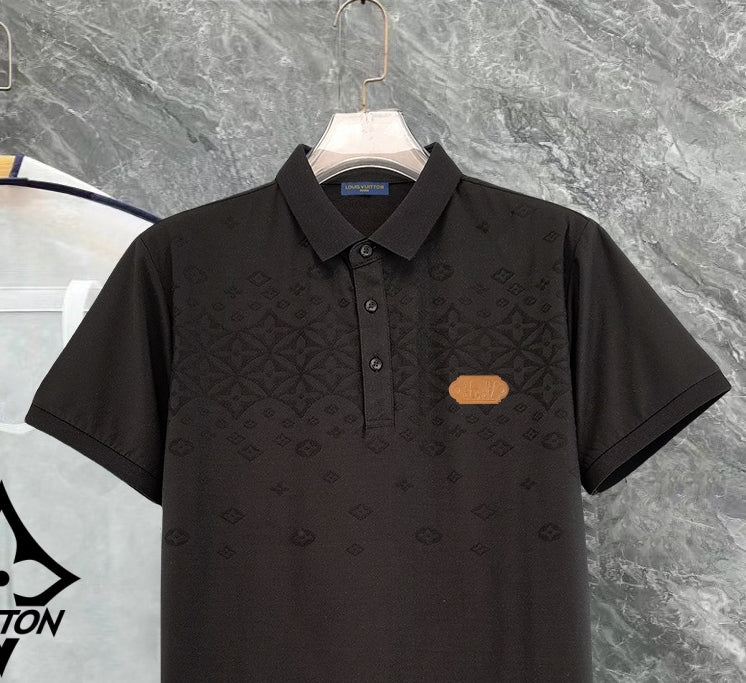 Black monogram polo shirt close-up with button placket and chest patch