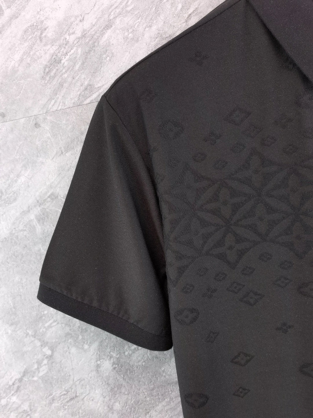 Louis Vuitton black polo shirt, side view with textured all-over pattern detail