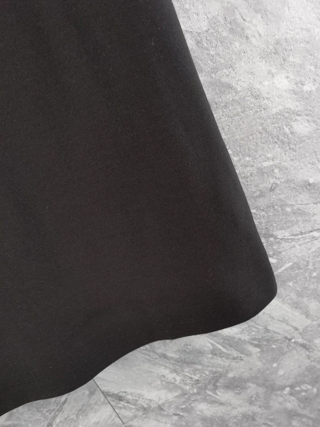 Black polo shirt hem and curved side seam detail