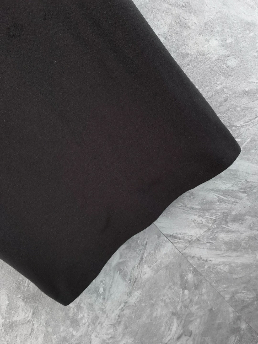 Louis Vuitton black polo shirt sleeve hem close-up with smooth fabric finish