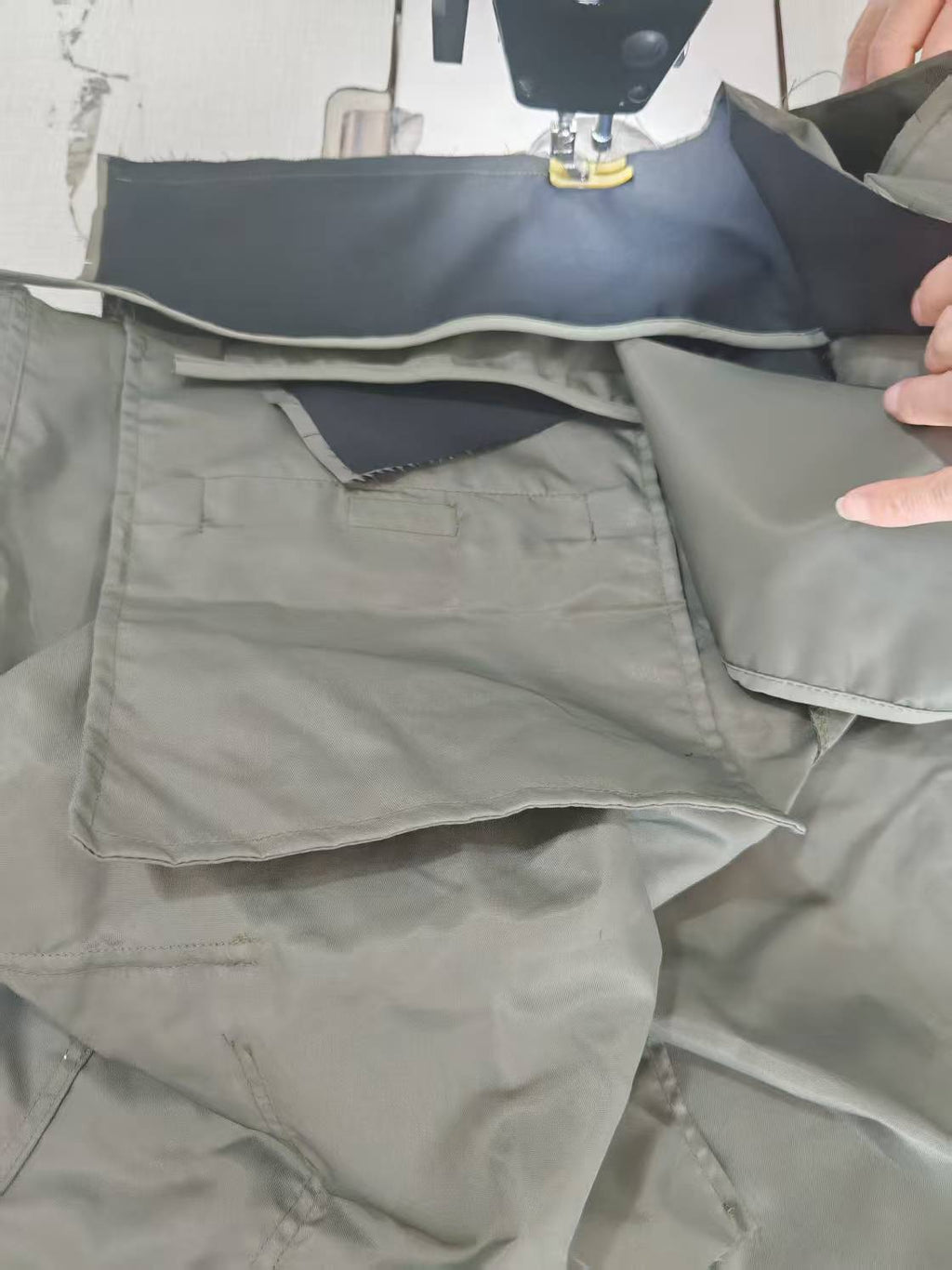 Light gray cargo pants with side pockets and stitched seams