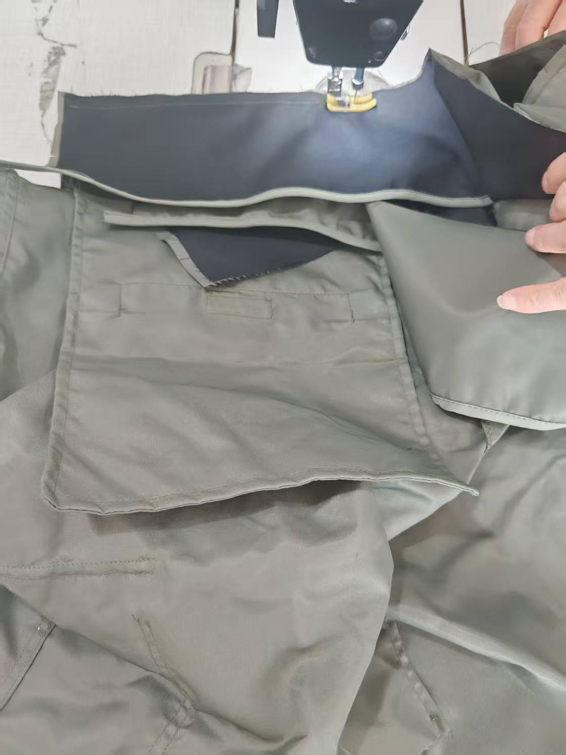 Light gray cargo pants with side pockets and stitched seams