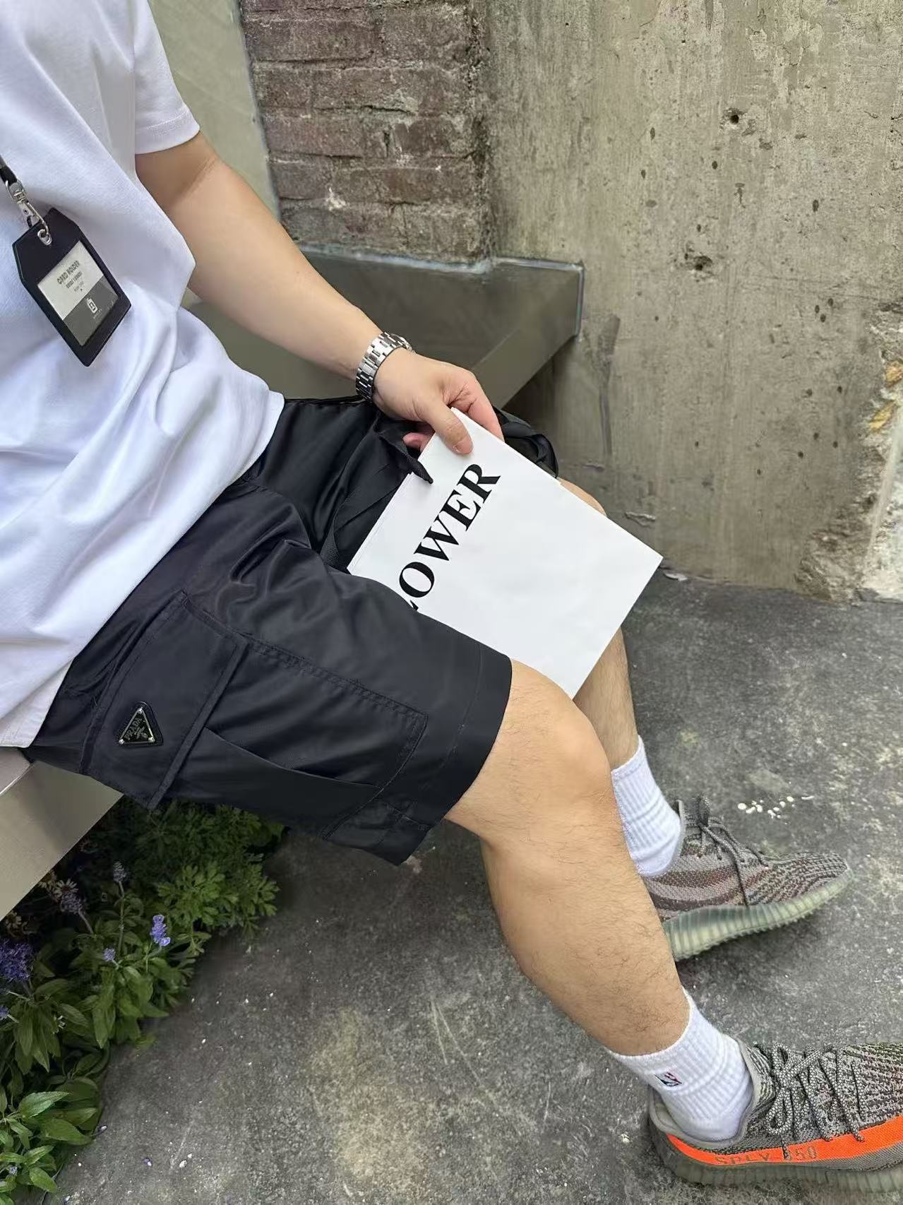 Black knee-length cargo-style shorts with triangular emblem