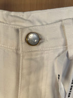 White denim pants close-up of waistband with round front button