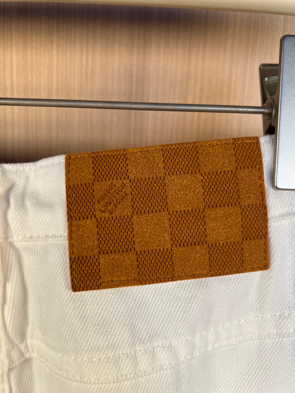 White denim pants close-up of brown patterned back pocket patch