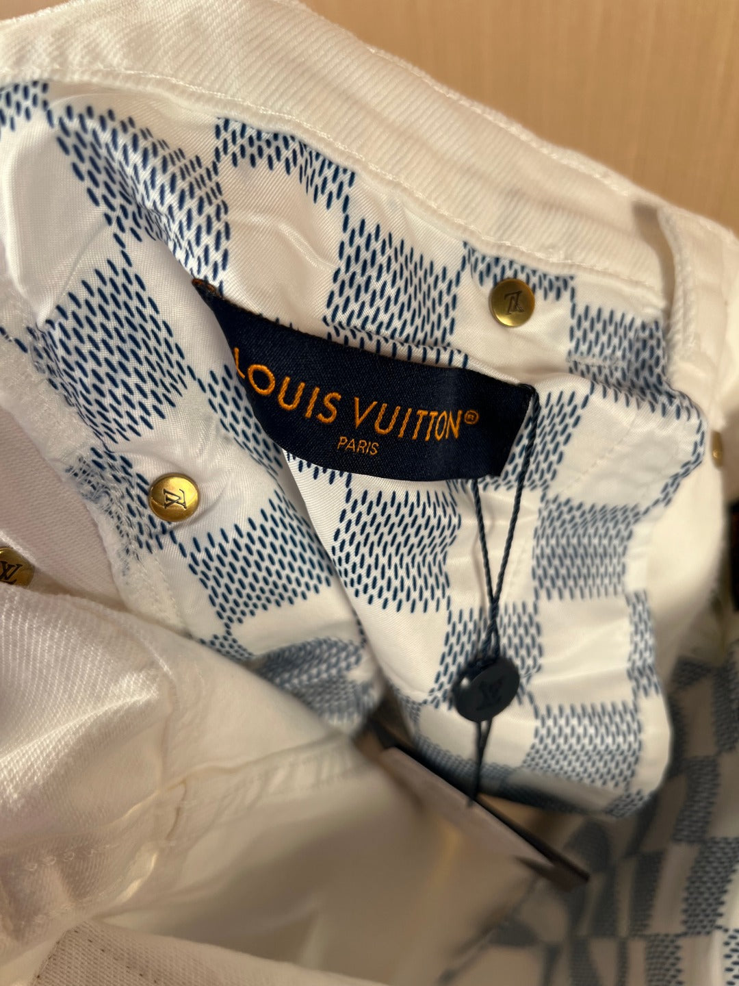 White denim pants inner waistband with blue check label and brand text