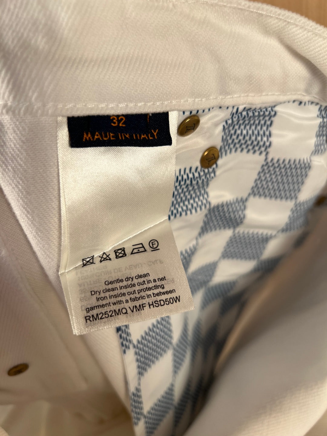 White denim pants care label with size 32 and made in Italy