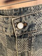 Denim front pocket with metal button and check pattern; stitched details
