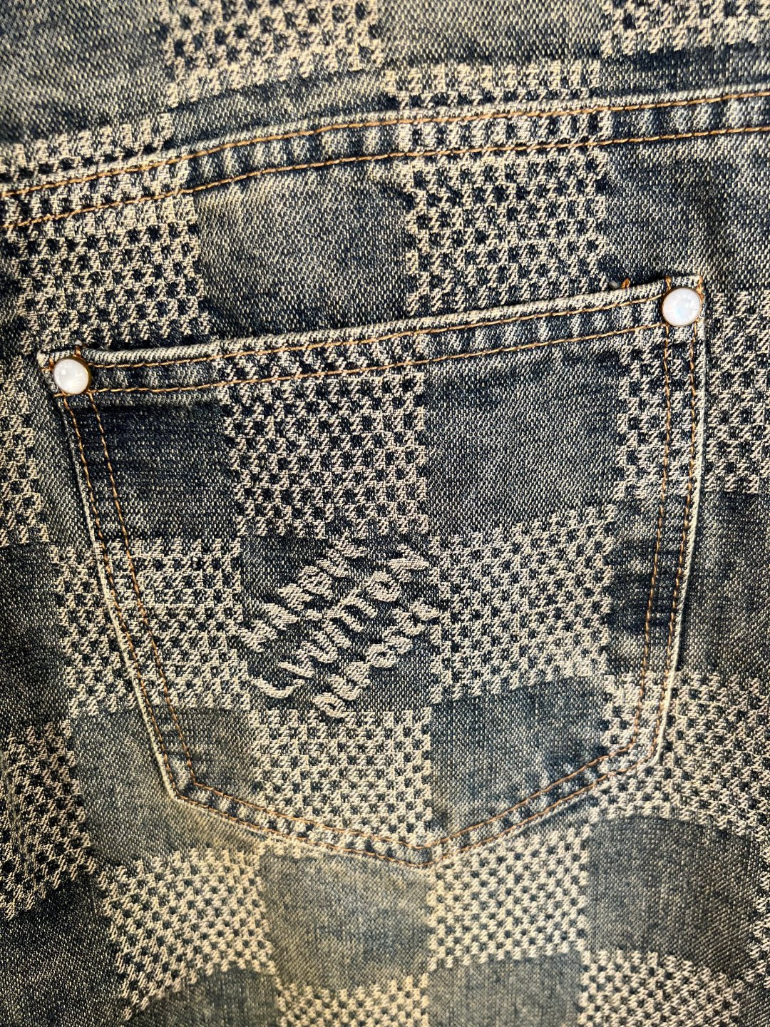 Denim patch pocket with embroidered emblem and stitch seams, check pattern