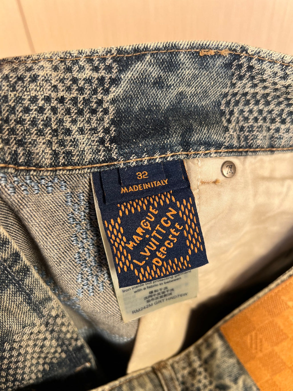 Fabric care tag with size 32 and made in Italy on denim lining