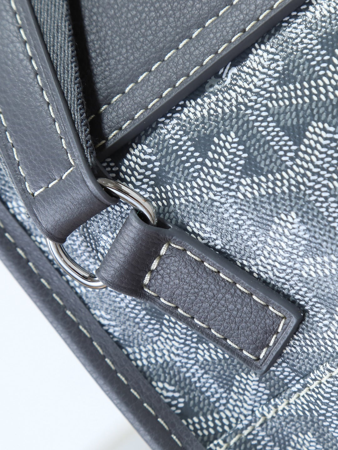 Goyard shoulder bag close-up of stitched trim and leather tab with metal ring