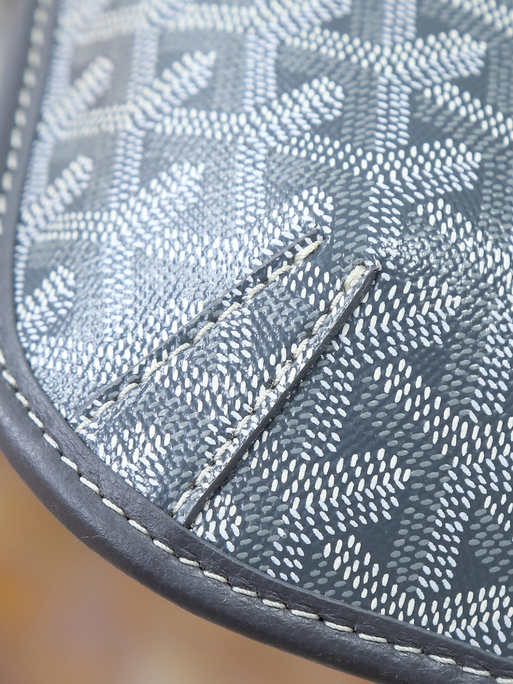 Goyard shoulder bag close-up of monogram canvas panel with stitched leather edge