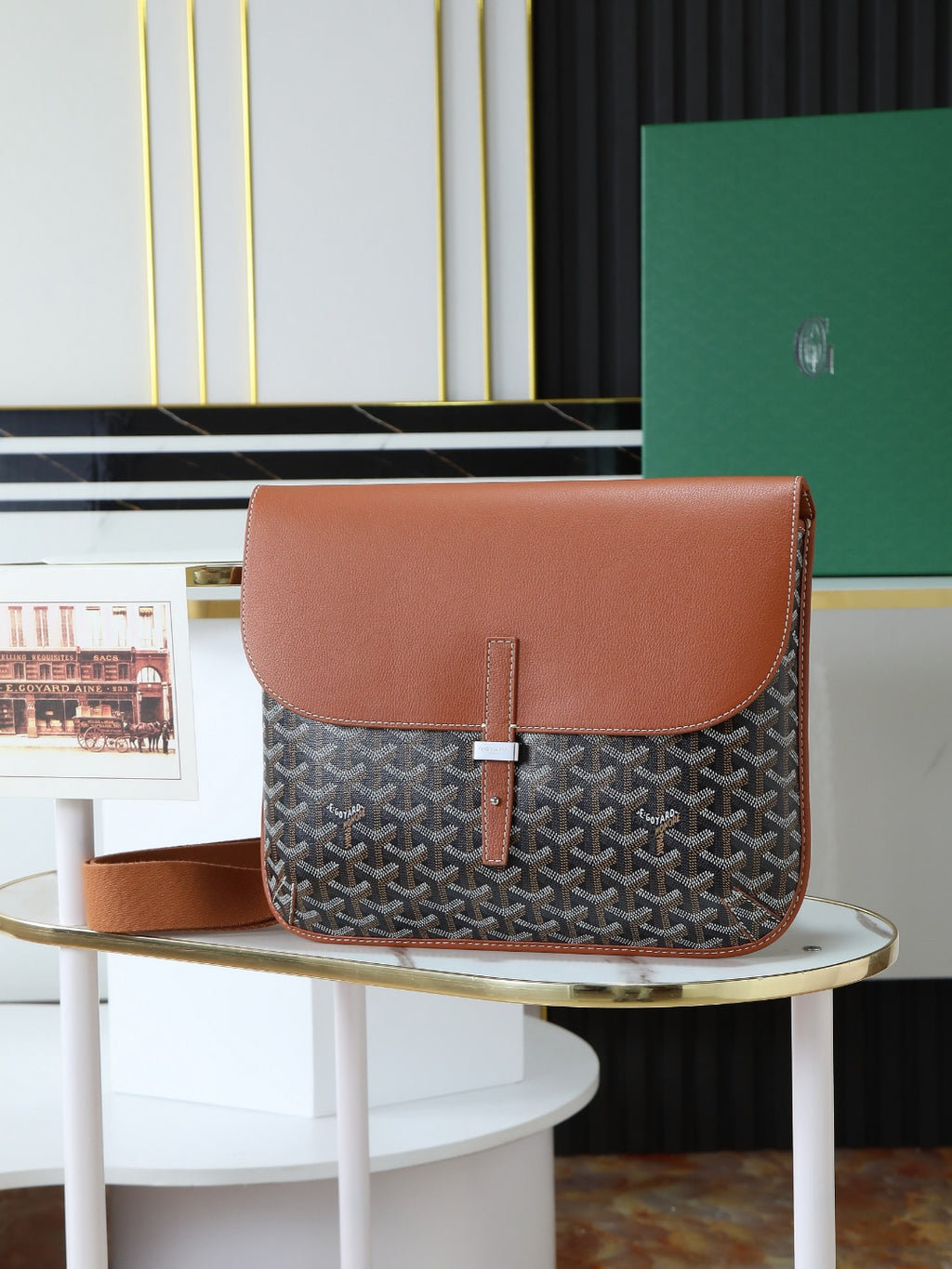 Goyard crossbody bag with brown leather flap and gray monogram canvas.