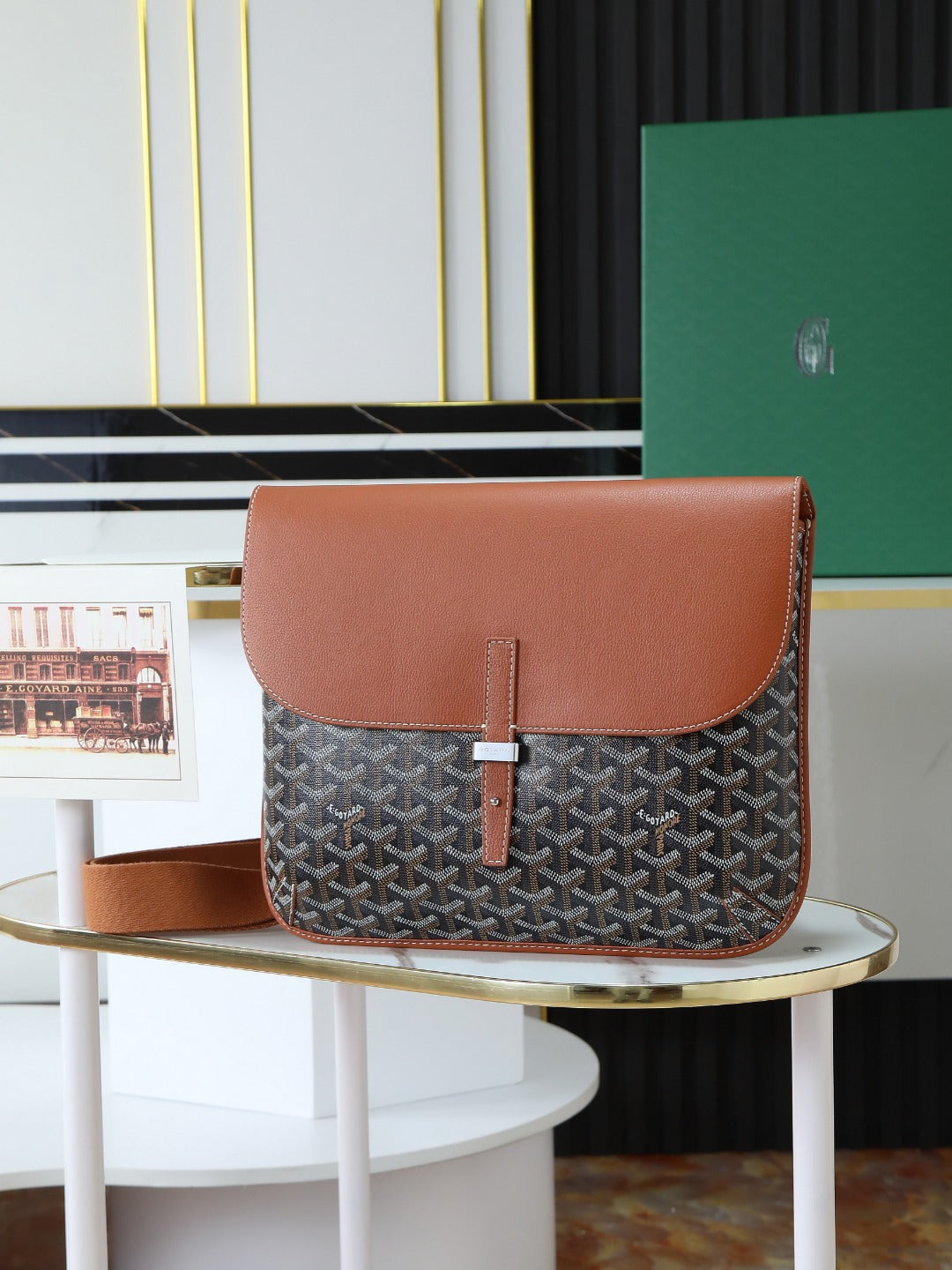 Goyard crossbody bag with brown leather flap and gray monogram canvas.