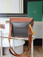 Goyard shoulder bag with monogram canvas, brown handles, and hanging yellow tag.
