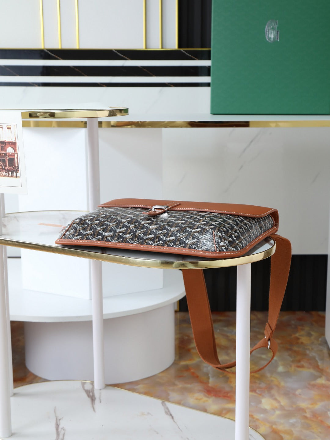 Goyard bag on stand with monogram top flap and brown leather trim.