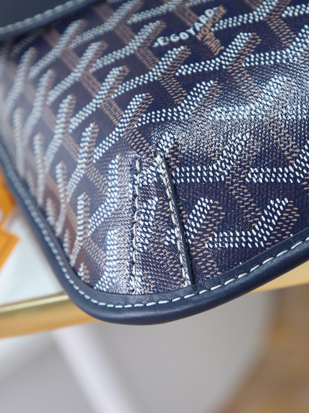 Goyard crossbody bag corner detail with dark blue monogram canvas and stitched edging