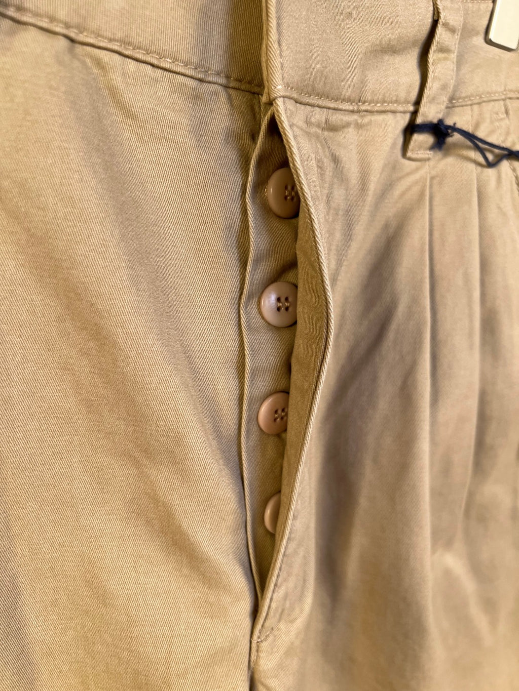 Khaki Prada shorts front with button fly and triple-button closure
