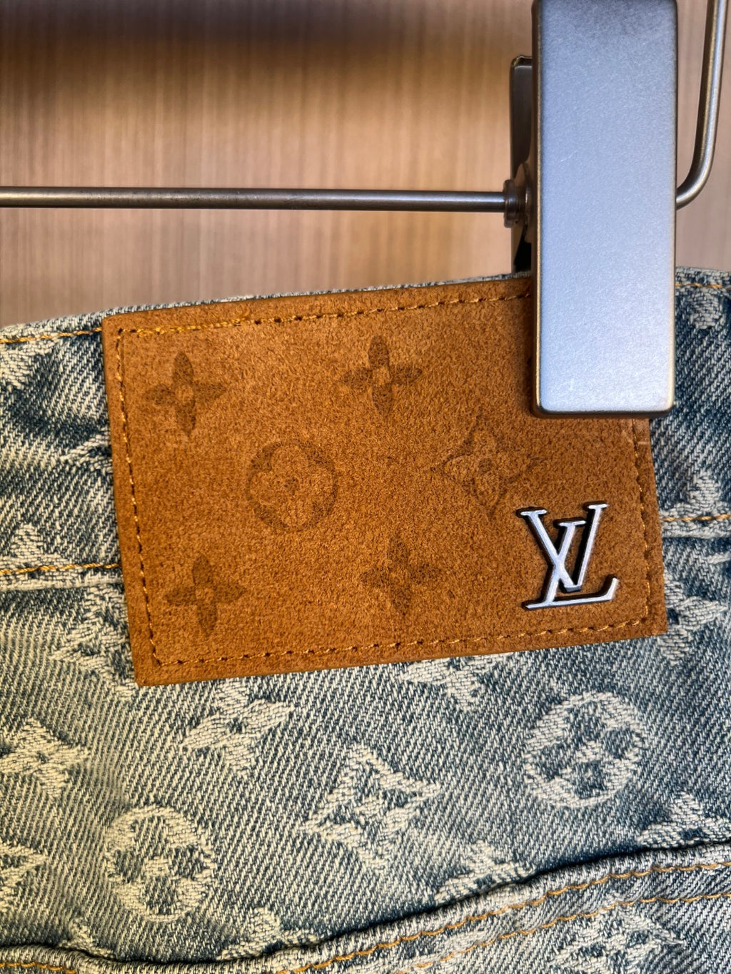 Brown leather brand patch with Louis Vuitton logo on denim pants waistband