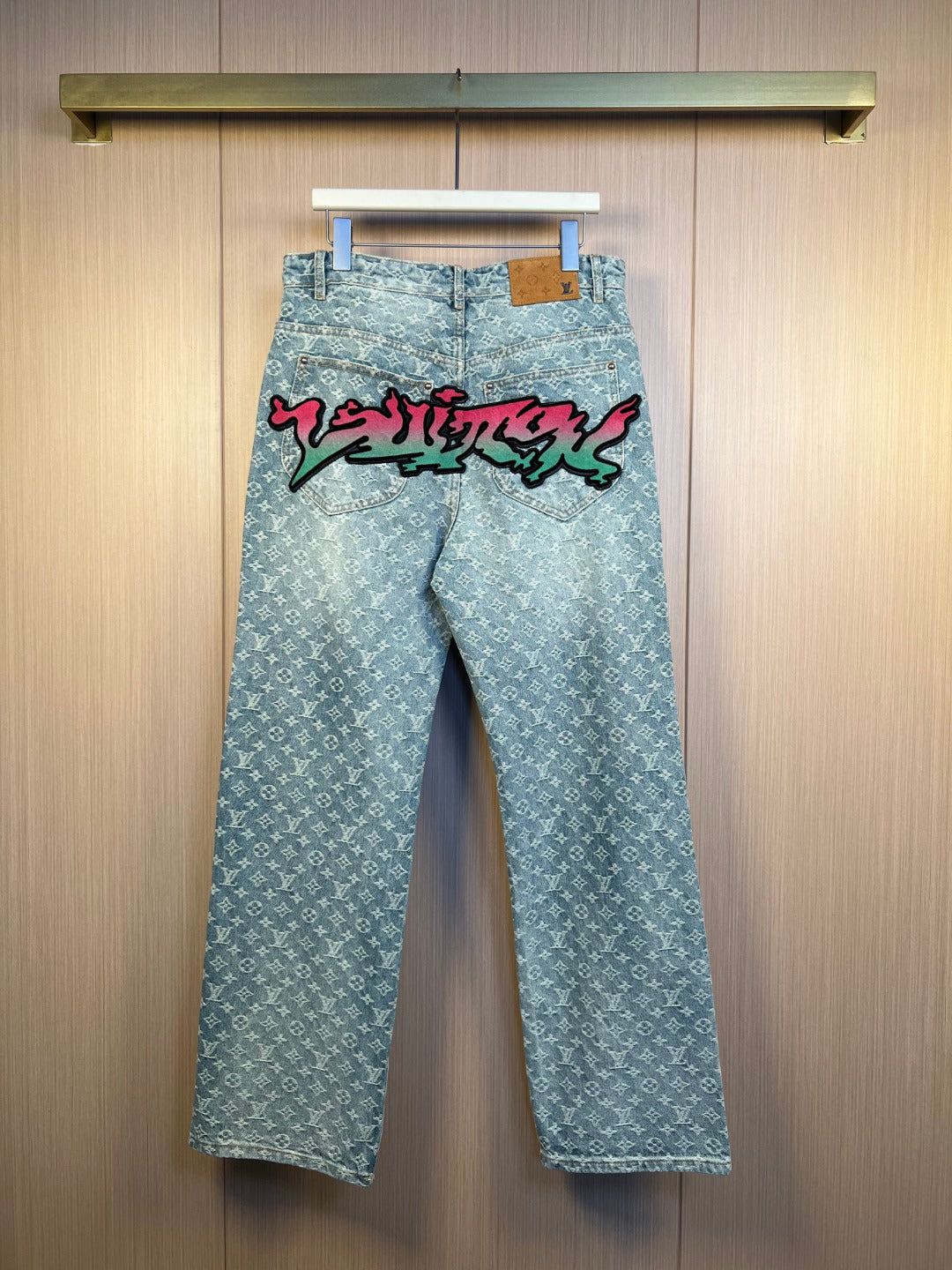 Light blue monogram denim pants with colorful graffiti print at the front