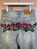 Light blue monogram denim pants with long colorful graffiti across the front