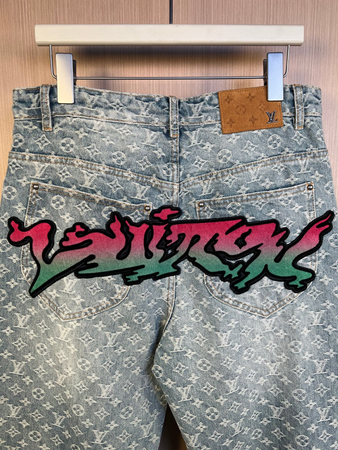 Light blue monogram denim pants with long colorful graffiti across the front