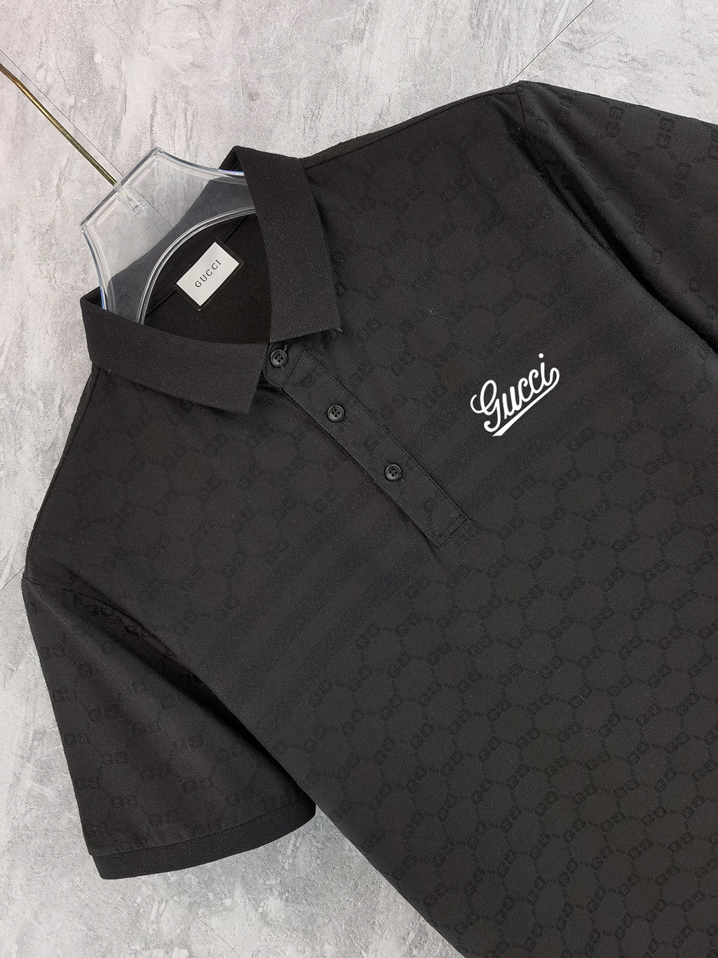 Black Gucci polo shirt close-up front, collar and button placket, script logo
