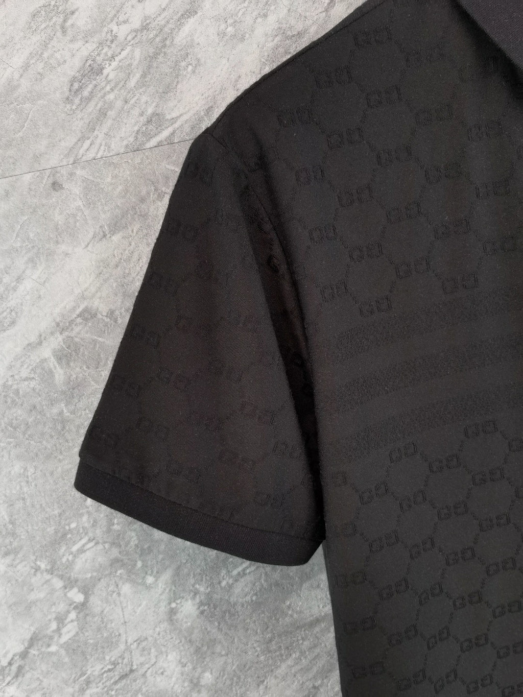 Black Gucci polo shirt side view on hanger, short sleeves and collar