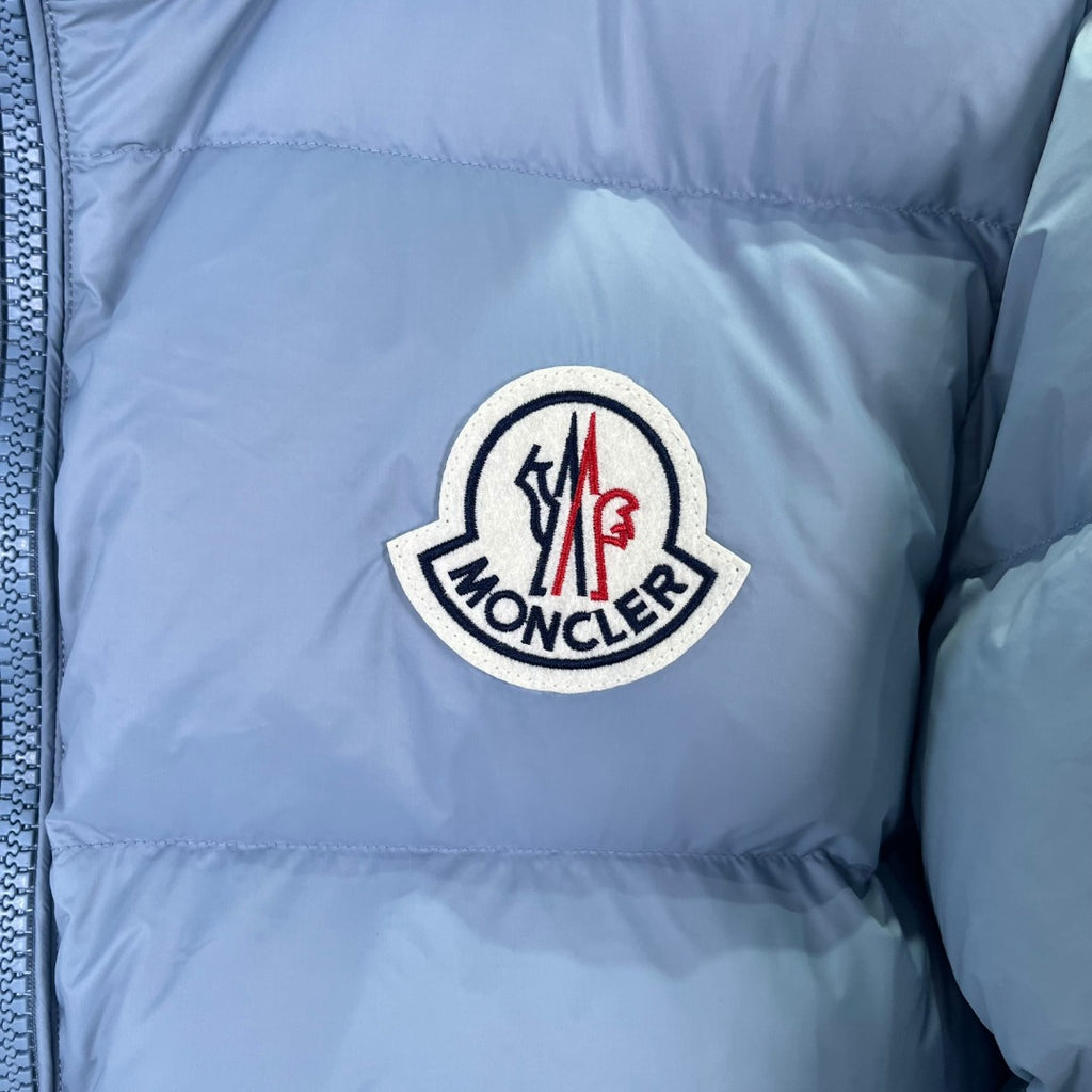Moncler logo patch on light blue puffer jacket chest