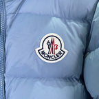 Moncler logo patch on light blue puffer jacket chest