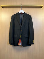 Dark blazer with notch lapels, flap pockets, and gold-tone button detailing