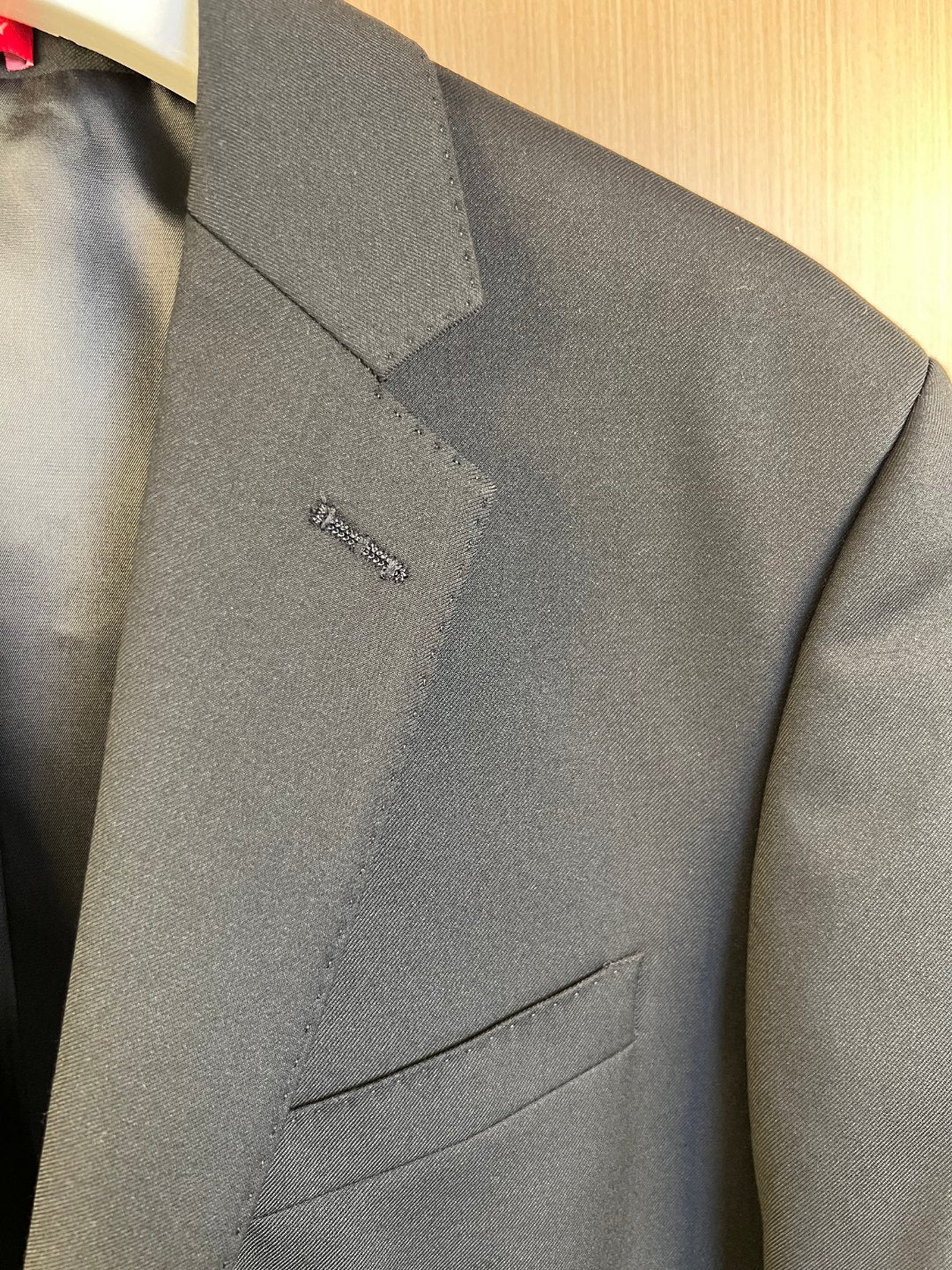 Dark blazer lapel with small embroidered detail